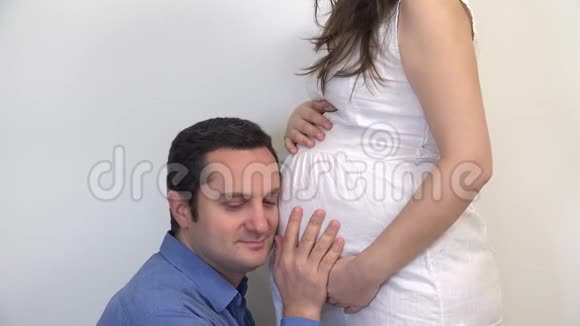 快乐男人在孕妇肚子孩子心跳微笑爸爸快乐视频的预览图