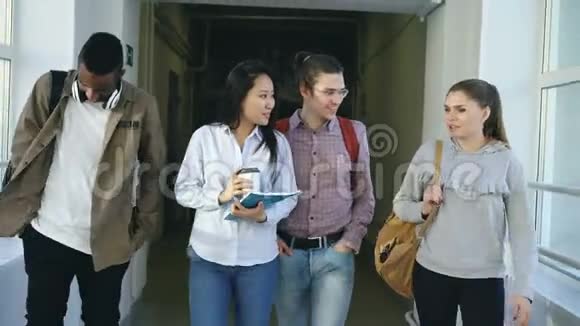 一群男女学生在大学的大走廊里微笑着讨论学习问题视频的预览图