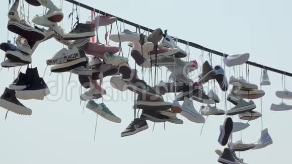 许多时髦的运动鞋都挂在户外的绳索上斜向天空视频的预览图