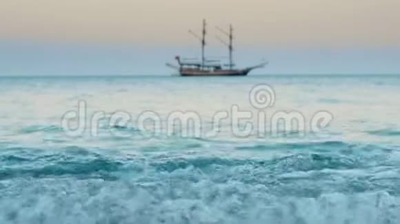 美丽的海景地平线上有帆船海浪拍打着海岸视频的预览图