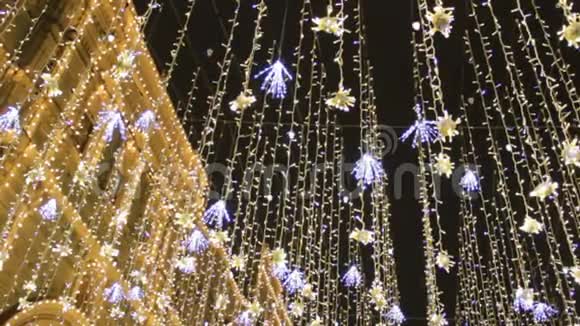 为圣诞节和新年庆祝而装饰的街道底景上装饰灯泡金雨仿视频的预览图