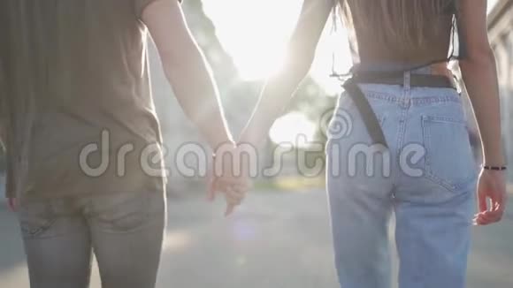 年轻有魅力的一对夫妇在日落时携手走在街上100fps的慢速运动视频的预览图