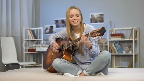 女吉他手在家表演歌曲有创作爱好准备试镜视频的预览图