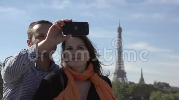 幸福夫妇自拍的肖像埃菲尔铁塔的背景男人和女人微笑甜蜜的温柔视频的预览图