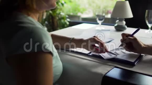 两个女商人拿着文件坐在咖啡馆的桌子上视频的预览图