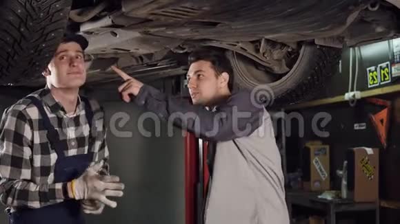 机械师和他的男性客户检查修理过的小静脉顾客与汽车维修服务部门握手视频的预览图