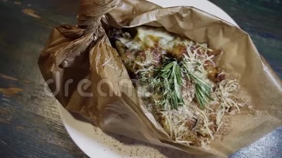 一些用奶酪刨花草药和香料覆盖在包装纸上的食物的俯视图视频的预览图
