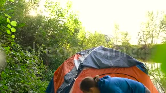 女人正在河岸上搭一个旅游帐篷在里面休息视频的预览图