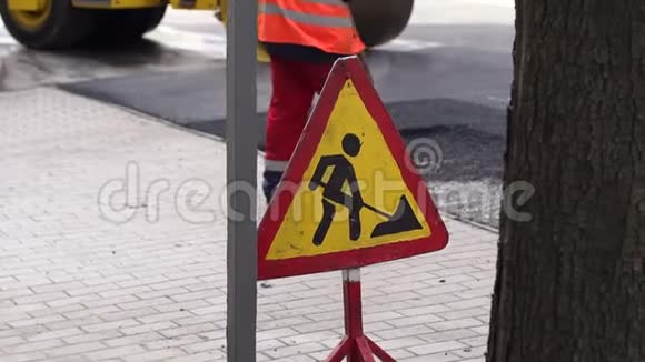 街道上的道路工程标志工人们把城市里的新沥青铺在路上视频的预览图