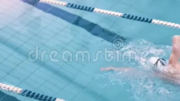 泳镜和泳帽的高角度欧洲游泳者在游泳池的跑道上漂浮视频的预览图