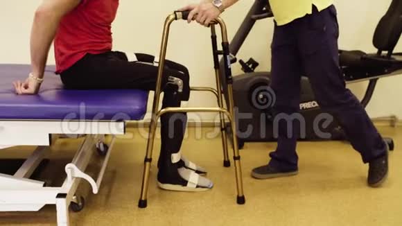 一个残疾人从医疗沙发上站起来抱着步行者视频的预览图