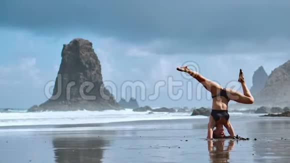 夏季日出瑜伽课程在美丽的普拉亚德拉提塔海滩观赏大西洋和蓬塔罗亚岩视频的预览图