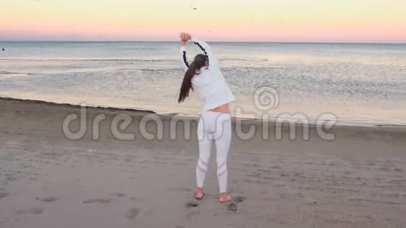 年轻女子正在做运动以恢复呼吸在沙滩上日出在秋天视频的预览图