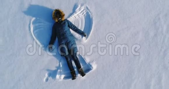 女人让雪天使躺在雪地里空中录像视频的预览图