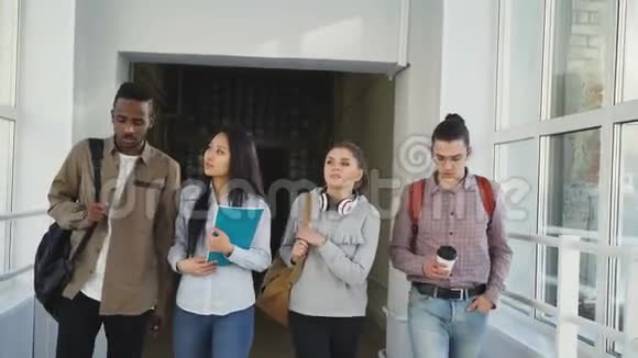 四位来自不同民族的男女学生正沿着白色宽敞的大学走去视频的预览图