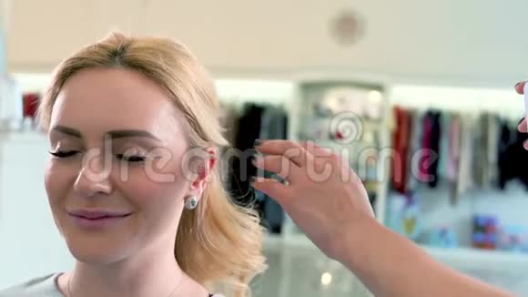 美容师在美容院给一个金发女人喷发视频的预览图