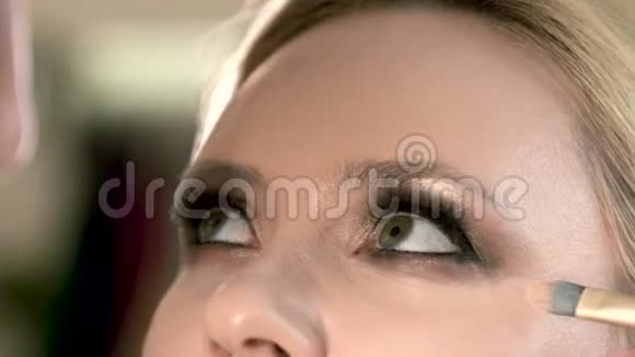 化妆师用刷子粉底液粉做模型应用化妆底座特写质感女人的脸视频的预览图