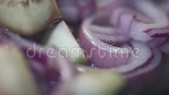 洋葱圈和茄子块的宏观视图放在锅上和蒸视频的预览图