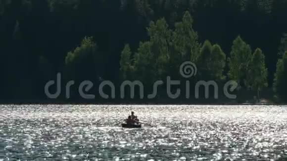 乘坐划桨船的人在山湖上度过夏日轻松的一天视频的预览图