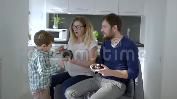 现代的童年父母抱着游戏控制器在教孩子玩电子游戏视频的预览图