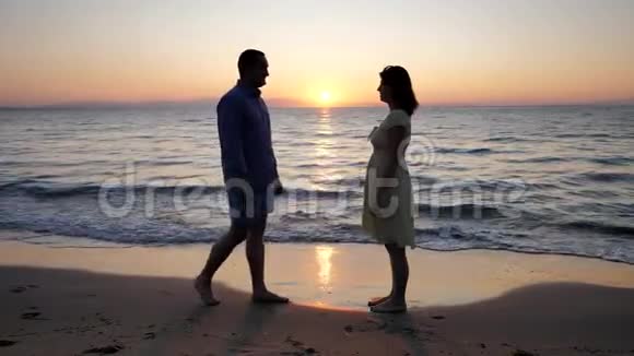 男人跪在沙滩上向情人求婚新生活的日出视频的预览图