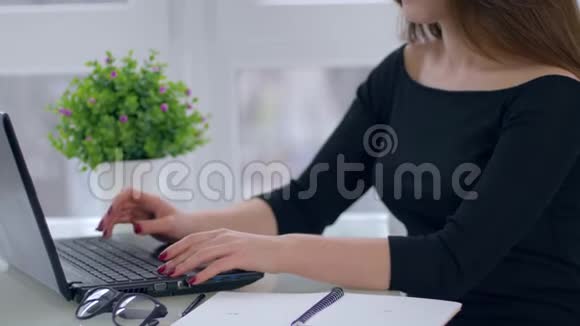 在网上工作年轻的女人拿着笔记本电脑坐在光办公室的桌子上视频的预览图