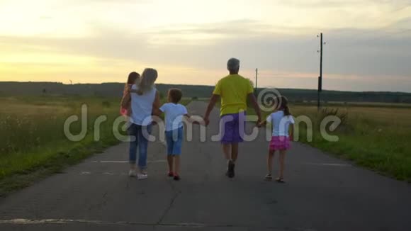 成熟的父母带着三个孩子在农村沿路走幸福的家庭在大自然中玩得很开心旅游旅游徒步旅行视频的预览图