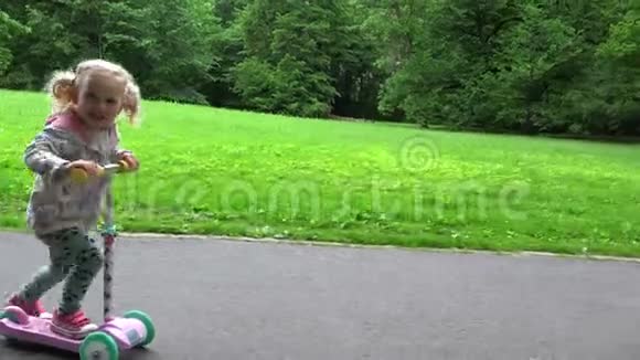 漂亮的小女孩正在骑滑板车公园休闲活动视频的预览图