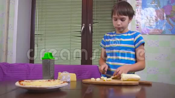 男孩在家做披萨他在准备奶酪视频的预览图