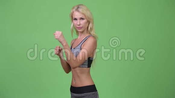 年轻美丽的女子在战斗的立场准备健身房视频的预览图