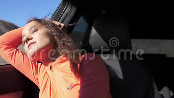 美丽的年轻黑发女人望着车窗外慢动作3840x2160视频的预览图