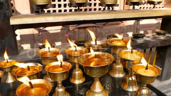 在寺庙里烧蜡烛观看金色闪亮的碗与燃烧的油烛火焰崇拜视频的预览图