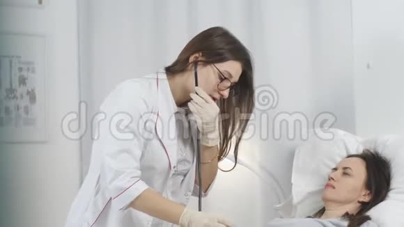医生对医院病房的病人进行常规检查听病人听诊器的女人视频的预览图