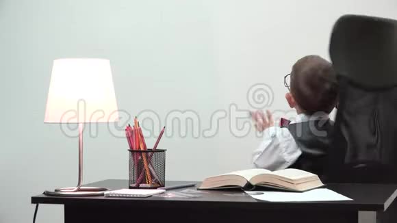桌上的有趣的小孩举起手来和桌子旋转好玩的小孩停止工作放松时间视频的预览图