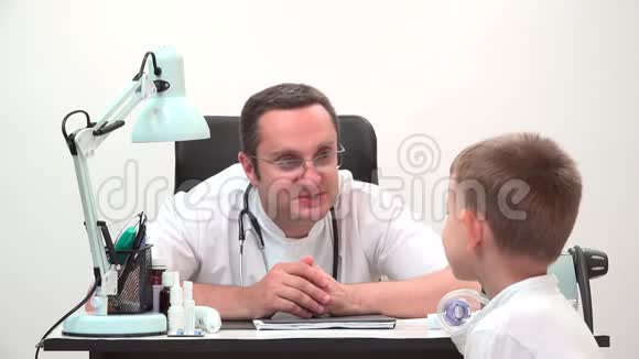 友好的医生在医院办公室和孩子谈话男人写了一个食谱视频的预览图