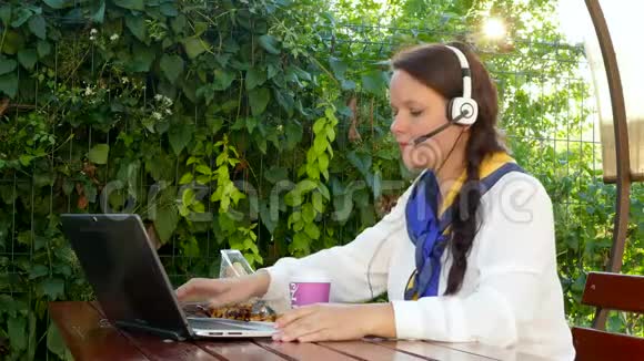 女人在户外笔记本电脑上通过互联网聊天视频的预览图