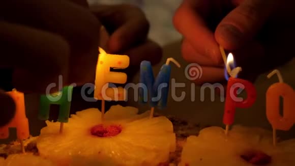 慢动作特写人们在生日蛋糕上点蜡烛视频的预览图