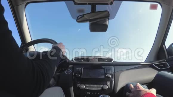 女人开车沿着公路阳光照在挡风玻璃上低角度视角视频的预览图