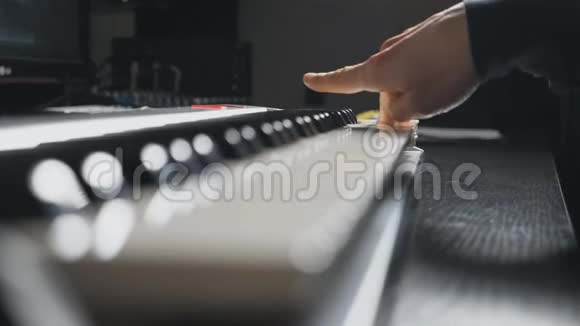 钢琴家的手指按在合成器键上在音响工作室工作男性手在弹钢琴侧视图视频的预览图
