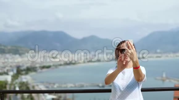 戴太阳镜的女人在城市的背景上自拍去不同的城市旅行视频的预览图