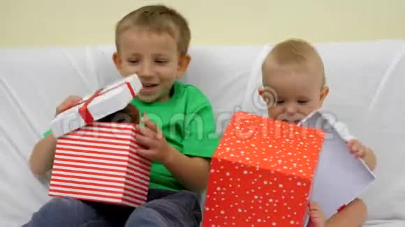 小兄弟看着礼物盒宝贝和孩子在盒子里找到泰迪熊视频的预览图