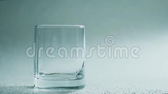 威士忌或白兰地倒入白色背景的玻璃杯中视频的预览图