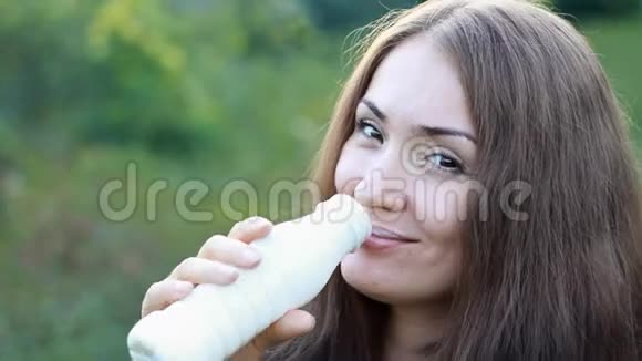 喝牛奶的女人牛奶凯菲酸奶女孩脸的特写肖像视频的预览图