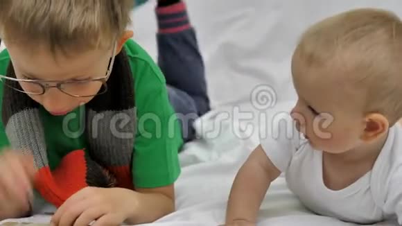 有趣的哥哥肚子上的碱液戴眼镜的哥哥给细心的宝宝读书视频的预览图