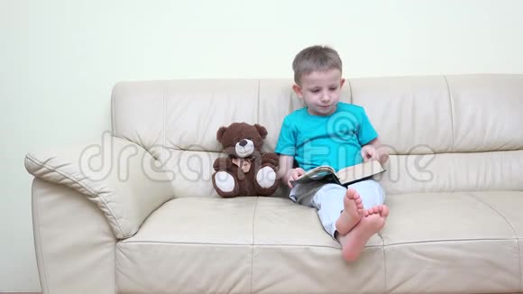 可爱的小男孩在家看书和玩具熊玩具聊天有趣的讲座视频的预览图