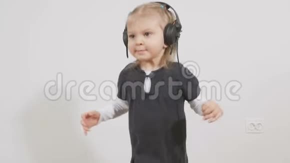 小女孩用耳机听音乐视频的预览图