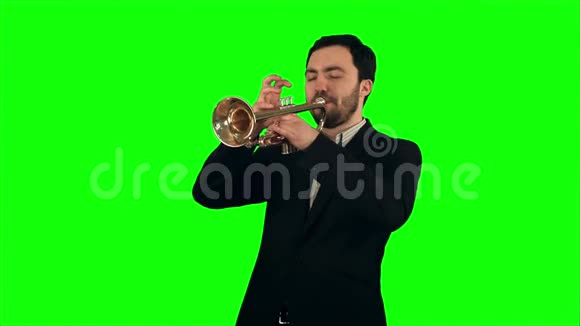 在绿屏上吹喇叭的年轻音乐家视频的预览图