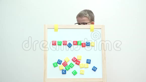 用大眼镜在白板后面书写的孩子视频的预览图