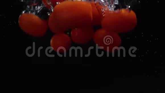 红西红柿掉落漂浮在水中黑色背景慢动作食物视频视频的预览图