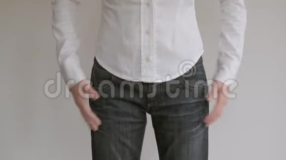 站在白墙前的女人检查裤子口袋里的东西视频的预览图